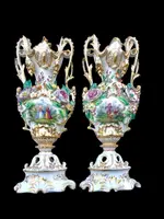 Pair of porcelain vases with two handles, featuring flowers in relief and plant motifs