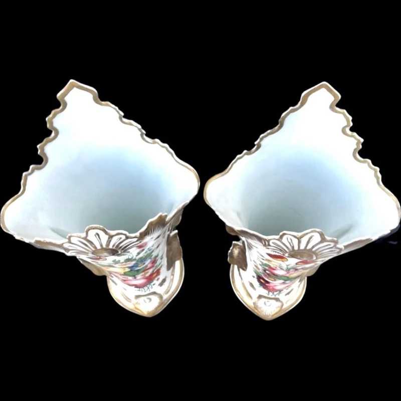 Pair of trumpet-shaped porcelain vases with leaf-shaped handles and floral motifs in relief