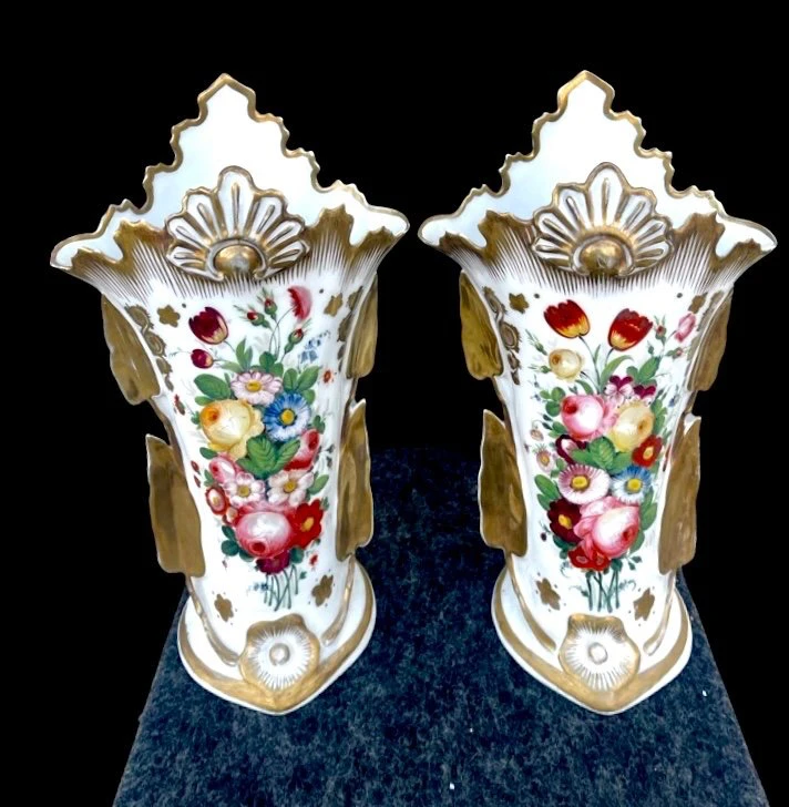 Pair of trumpet-shaped porcelain vases with leaf-shaped handles and floral motifs in relief