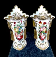 Pair of trumpet-shaped porcelain vases with leaf-shaped handles and floral motifs in relief