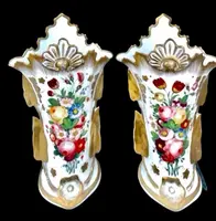 Pair of trumpet-shaped porcelain vases with leaf-shaped handles and floral motifs in relief