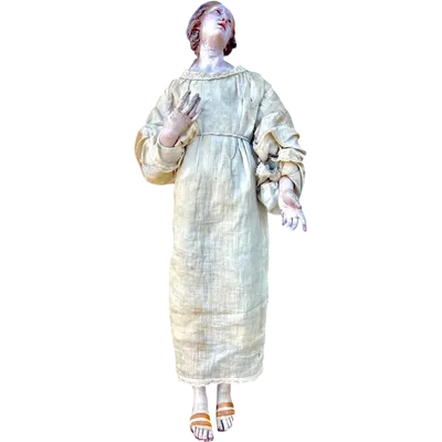 Nativity scene figurine with a terracotta face and a frame made of wood and fabric.