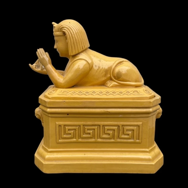 Mustard-colored earthenware box decorated with sphinxes and neoclassical motifs.