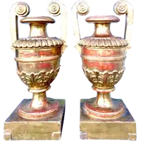A pair of neoclassical palm-shaped candleholders made of gilded wood with stylized leaf motifs.