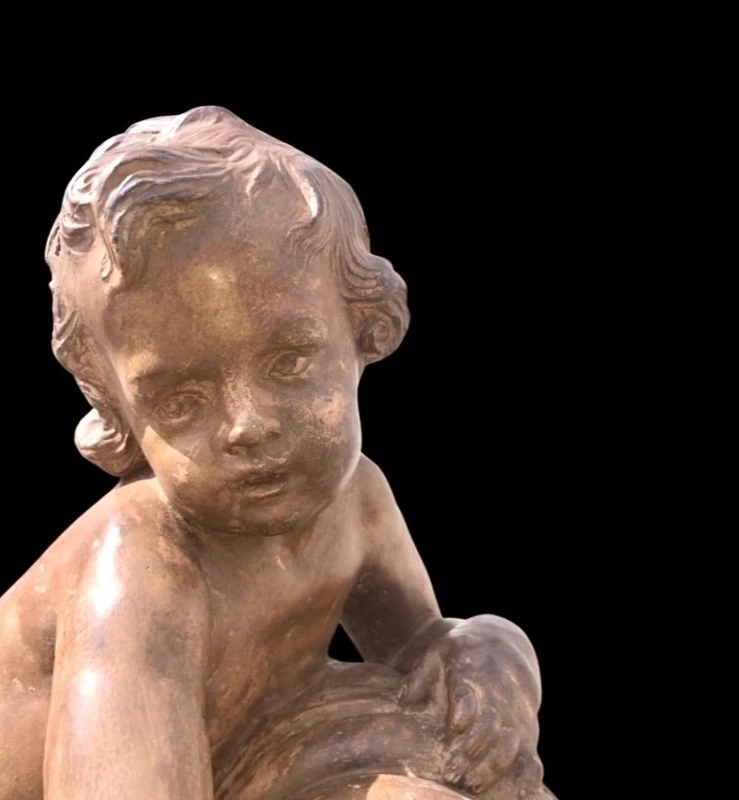 A terracotta sculpture depicting a child pouring liquid from a vase.