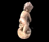 A terracotta sculpture depicting a child pouring liquid from a vase.