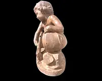 A terracotta sculpture depicting a child pouring liquid from a vase.