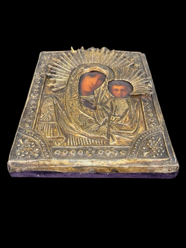 Icône représentant la Vierge à l'Enfant, avec un visage peint et une structure en feuille d'argent.