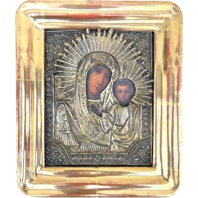 Icône représentant la Vierge à l'Enfant, avec un visage peint et une structure en feuille d'argent.