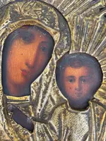 Icône représentant la Vierge à l'Enfant, avec un visage peint et une structure en feuille d'argent.
