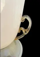Lampe en forme de coupe en verre doublé de couleur ambre-laiteux, à deux anses, avec des incrustations en or.