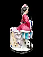 Porcelain tobacco box featuring a female figure with a rifle and a drum.