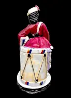 Porcelain tobacco box featuring a female figure with a rifle and a drum.
