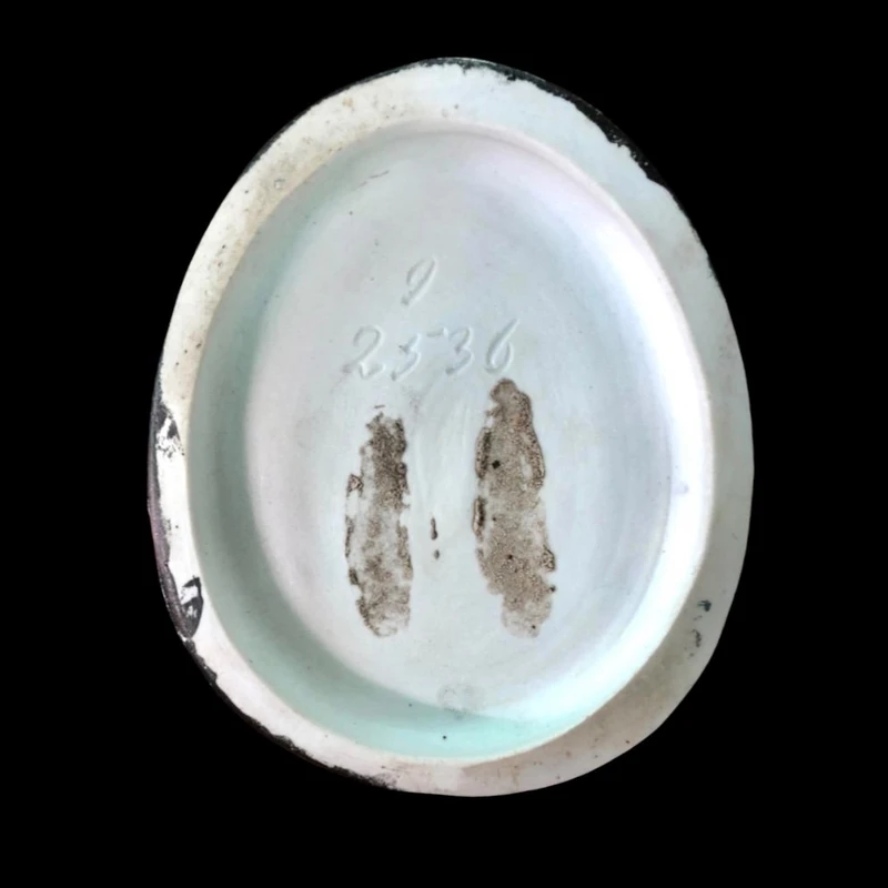 Porcelain tobacco box featuring a seated female figure holding a cigar.