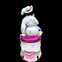Porcelain tobacco box featuring a seated female figure holding a cigar.