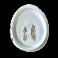 Porcelain tobacco box featuring a seated female figure holding a cigar.