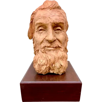 Terracotta sculpture depicting the head of a bearded man. Wooden base.
