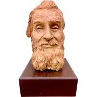 Terracotta sculpture depicting the head of a bearded man. Wooden base.