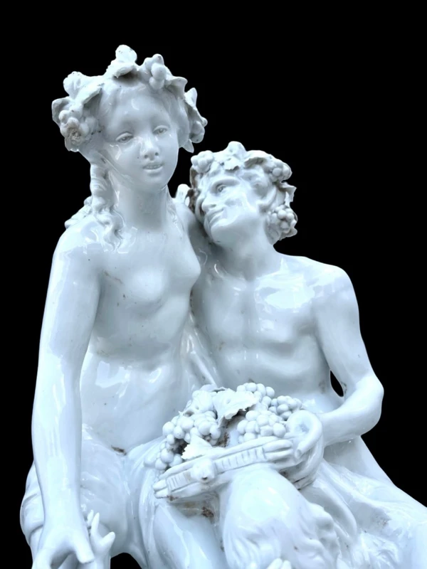 Large porcelain sculpture (masso bastardo) depicting a faun and a nymph with a cherub