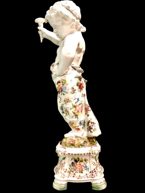 A pair of large majolica candlesticks featuring cherubs and polychrome floral decoration.