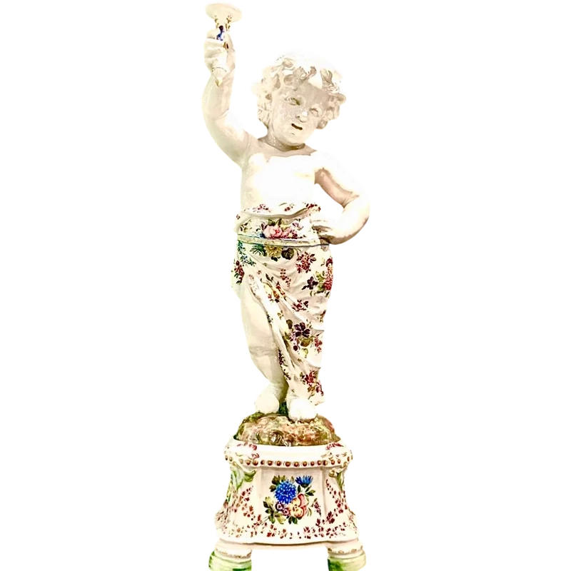 A pair of large majolica candlesticks featuring cherubs and polychrome floral decoration.