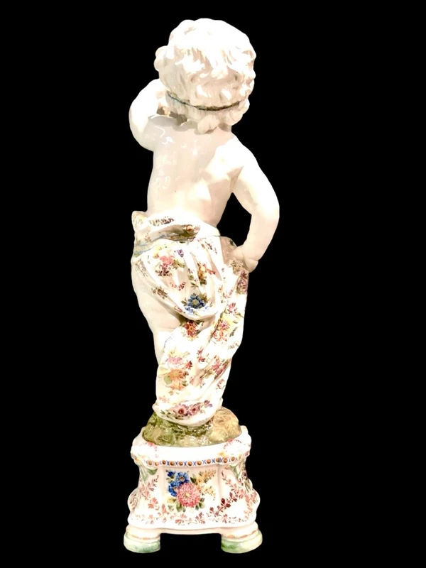 A pair of large majolica candlesticks featuring cherubs and polychrome floral decoration.