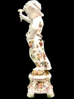 A pair of large majolica candlesticks featuring cherubs and polychrome floral decoration.