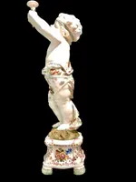 A pair of large majolica candlesticks featuring cherubs and polychrome floral decoration.