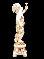A pair of large majolica candlesticks featuring cherubs and polychrome floral decoration.