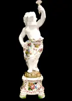 A pair of large majolica candlesticks featuring cherubs and polychrome floral decoration.