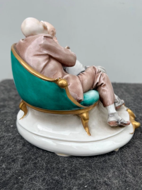 Sculpture caricaturale en porcelaine représentant deux amis qui se chuchotent à l'oreille.