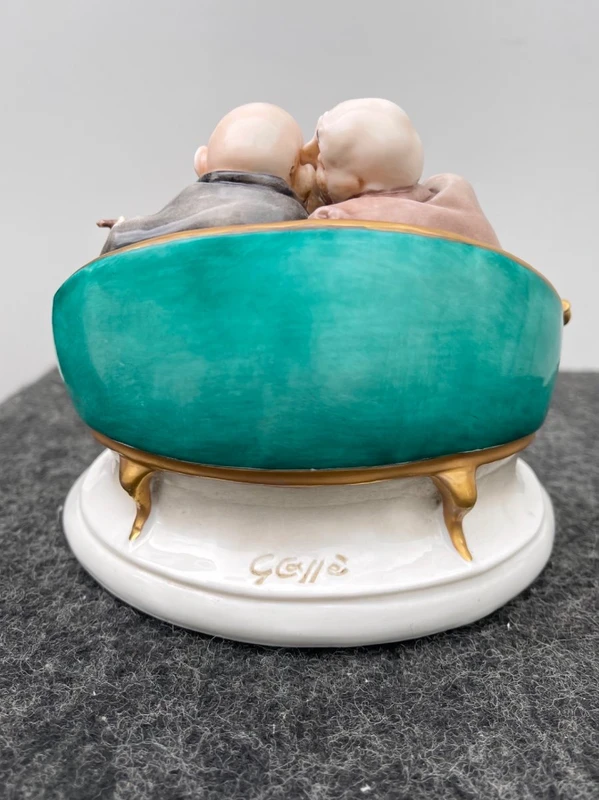 Sculpture caricaturale en porcelaine représentant deux amis qui se chuchotent à l'oreille.