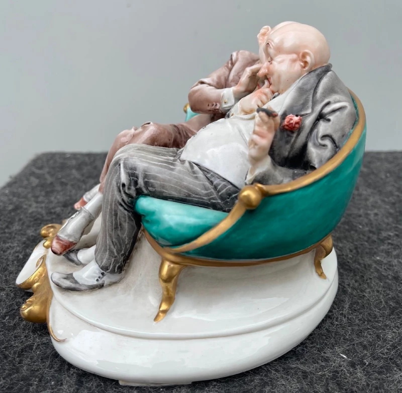 Sculpture caricaturale en porcelaine représentant deux amis qui se chuchotent à l'oreille.