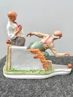 A caricature-style porcelain sculpture depicting bocce players.