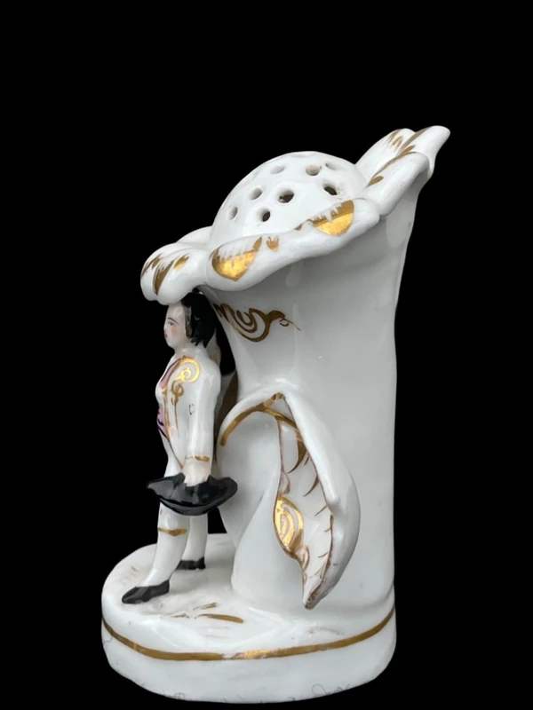 Polychrome porcelain toothpick holder featuring a male figure and shaped like a flower.