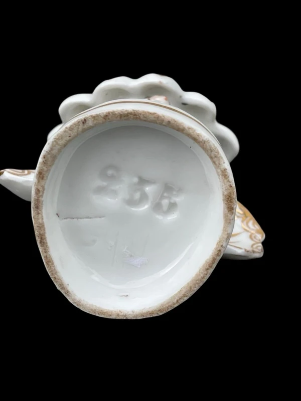 Polychrome porcelain toothpick holder featuring a male figure and shaped like a flower.