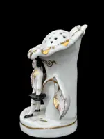 Polychrome porcelain toothpick holder featuring a male figure and shaped like a flower.
