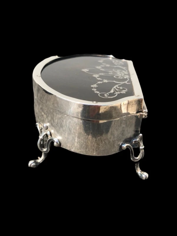 A silver box with a four-legged tortoise design and Art Nouveau floral inlays.