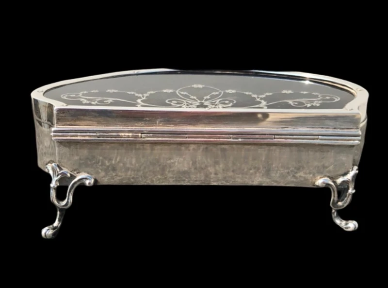 A silver box with a four-legged tortoise design and Art Nouveau floral inlays.