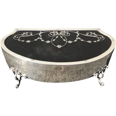 A silver box with a four-legged tortoise design and Art Nouveau floral inlays.