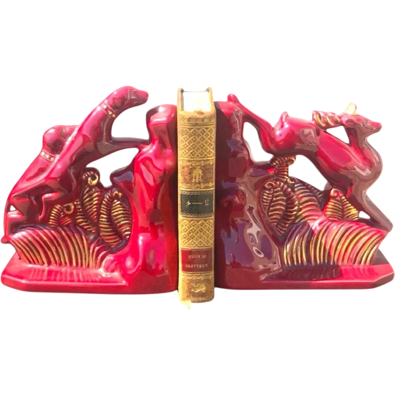 A pair of earthenware bookends depicting dogs chasing a deer.