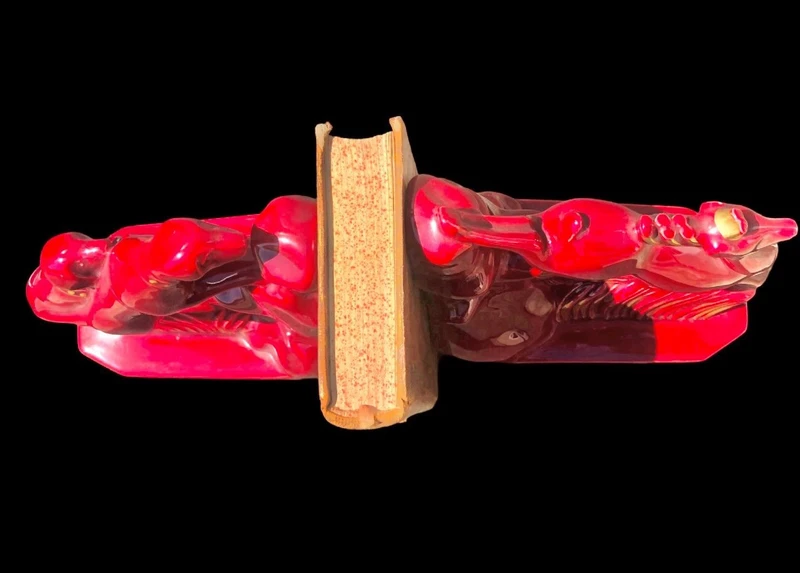 A pair of earthenware bookends depicting dogs chasing a deer.