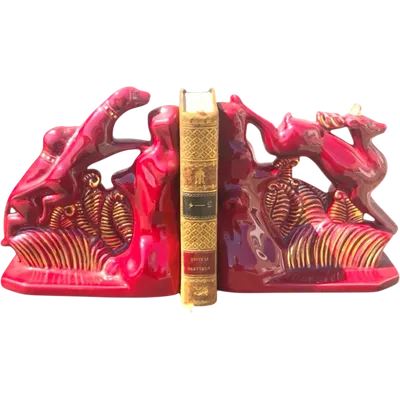 A pair of earthenware bookends depicting dogs chasing a deer.