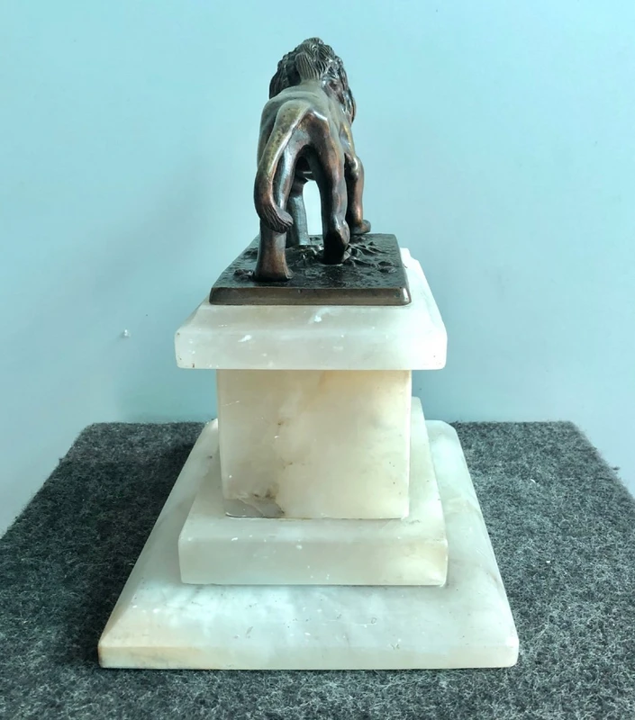 Bronze lion on an alabaster base.