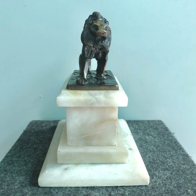 Bronze lion on an alabaster base.