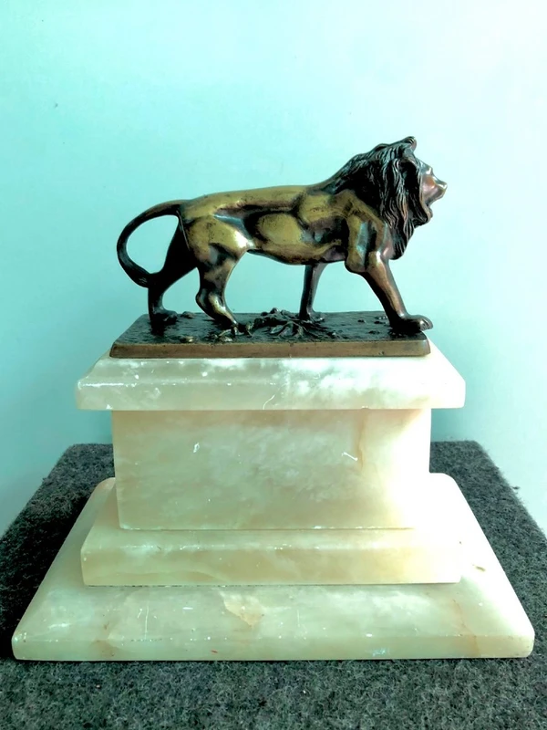 Bronze lion on an alabaster base.