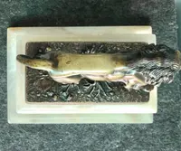 Bronze lion on an alabaster base.