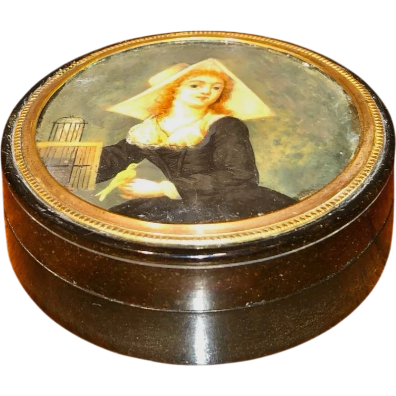 A small papier-mâché box with a miniature figure depicting a lady with a little bird.