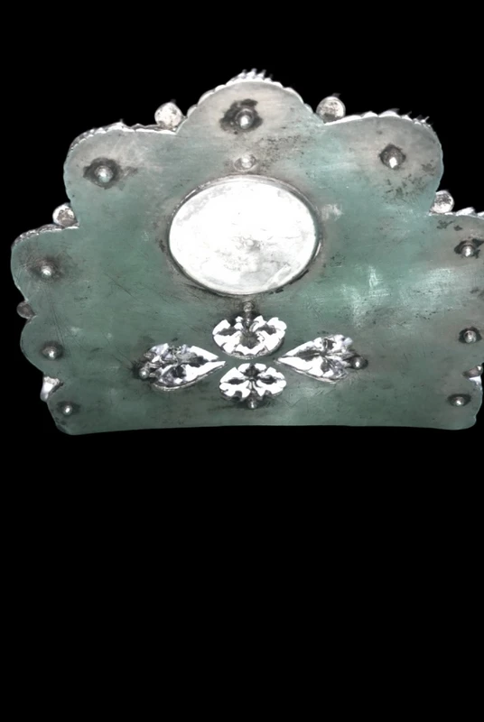 An inkwell made of embossed and openwork silver with stylized plant motifs and an enamel medallion.