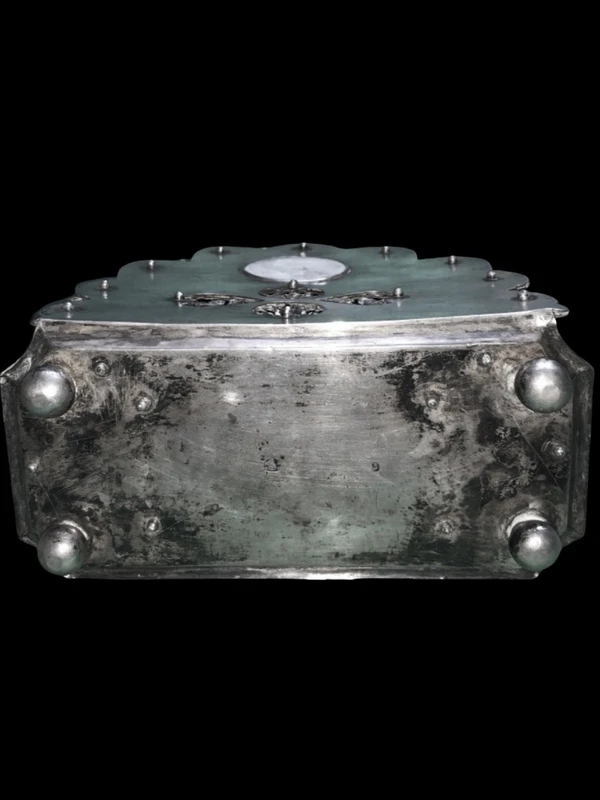 An inkwell made of embossed and openwork silver with stylized plant motifs and an enamel medallion.
